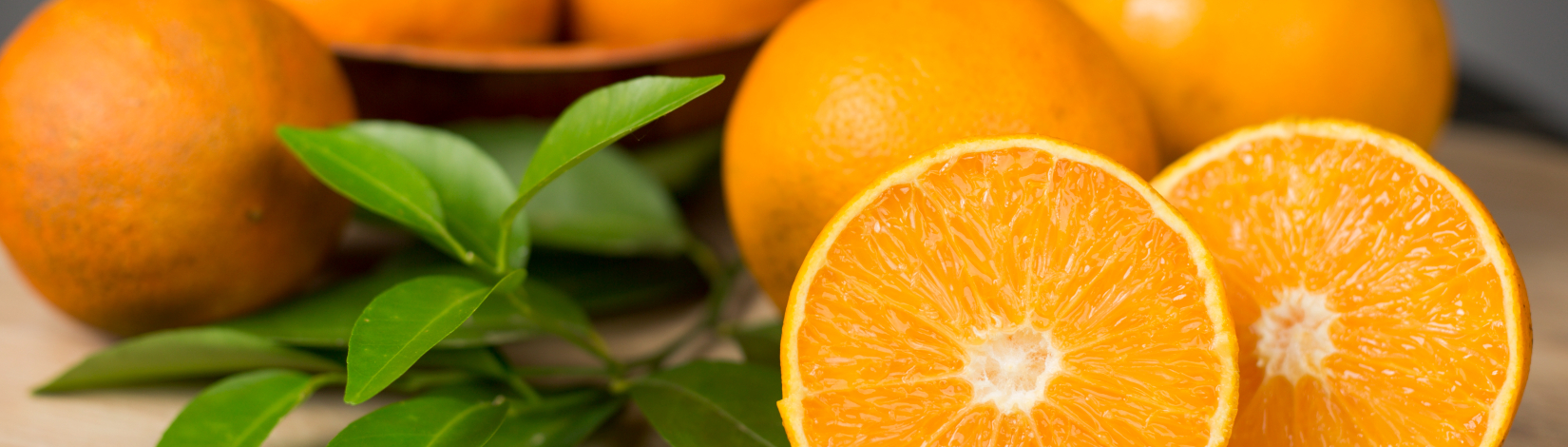 orange in a basket and a cut orange at the photo forefront